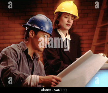 construction worker and architect at work site with blueprints Stock Photo