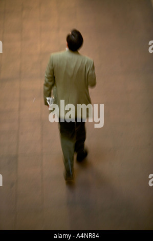 Man in tweed jacket walks away with a newspaper under his arm April 2005 USA Stock Photo