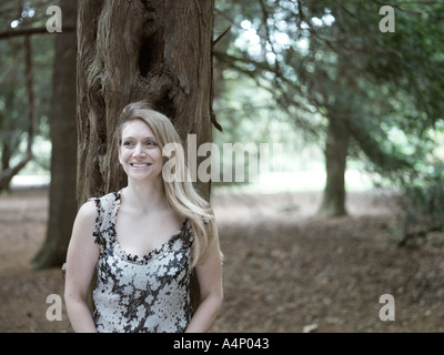 portrait of  woman smiling in front of tree Stock Photo