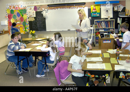 Teacher with students in Grade 3 male and female students in a classroom learning situation Stock Photo