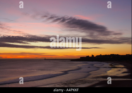 England Tyne and Wear Tynemouth Sunrise looking across longsands towards the North Tyne Pier lighthouse and the Tynemouth priory Stock Photo