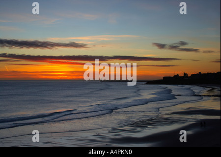 England Tyne and Wear Tynemouth Sunrise looking across longsands towards the North Tyne Pier lighthouse and the Tynemouth priory Stock Photo