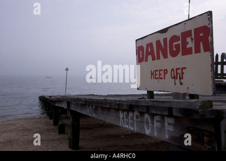 Danger keep off sign on jetty jutting out into Southend Estuary Essex Stock Photo