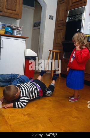 Young boy having moody tantrum as little girl looks worried. Stock Photo