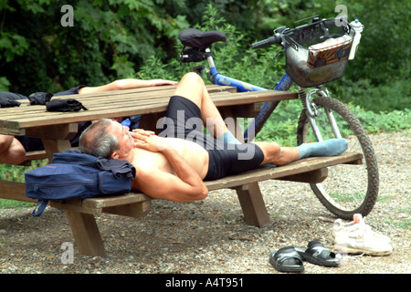 Sleeping Cyclist takes siesta on bank of Canal du Midi Southern France Stock Photo