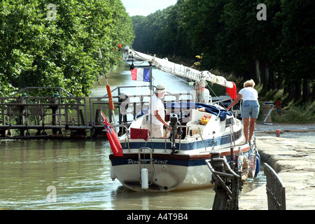 Newbridge 26 Yacht called Pioneer Spirit with mast down passing into lock on Canal du Midi Southern France Stock Photo