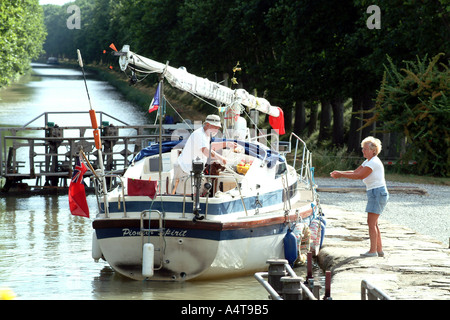 Newbridge 26 Yacht called Pioneer Spirit with mast down passing into lock on Canal du Midi Southern France Stock Photo