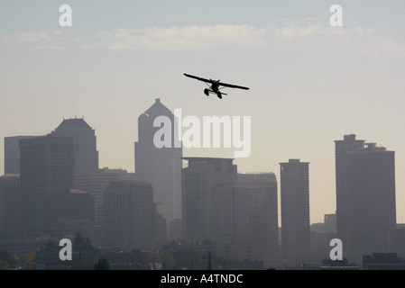 A Kenmore Air seaplane flys over the Seattle skyline to Lake Union in downtown Seattle. Stock Photo