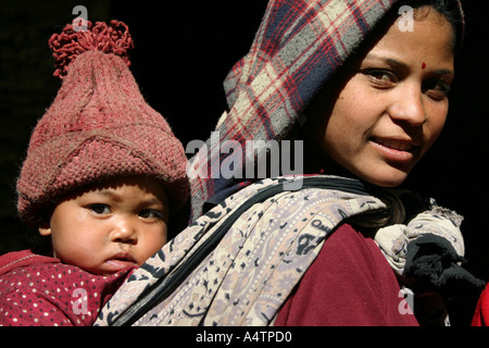 A young Nepalese mother carries her child on her back in the Upper Mustang region Stock Photo