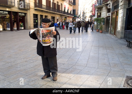 Man reading sports newspaper on pedestrianised street in Barcelona Spain Stock Photo
