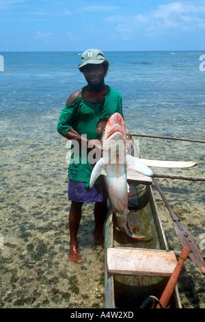 A shark caller from Kontu village on the West Coast of New Ireland brings in a shark he caught Stock Photo