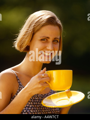 MARSHA NOVAK SHORT STRAIGHT HAIR PATTERNED TOP YELLOW CUP SAUCER Stock Photo