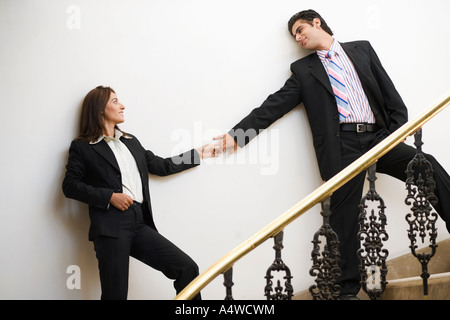 Businesspeople holding hands on staircase Stock Photo