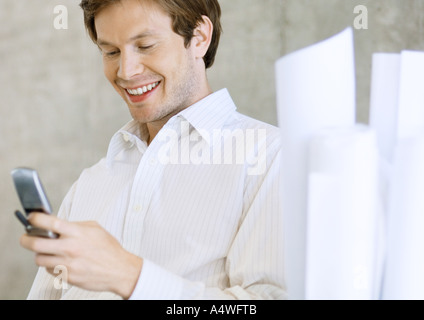 Architect holding cell phone, smiling Stock Photo