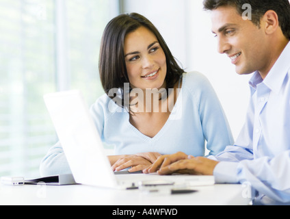 Woman and man working on laptop together Stock Photo