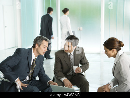 Business people sitting in lobby, having discussion Stock Photo
