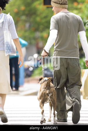 Young couple with dog crossing street Stock Photo