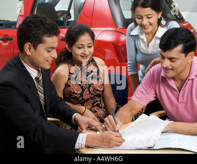 Family signing papers to buy new car Stock Photo