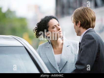Businesswoman and man speaking next to car Stock Photo