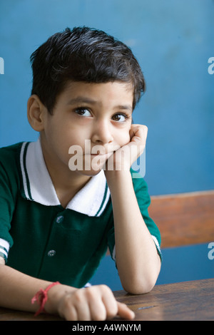 Young boy leaning on desk Stock Photo