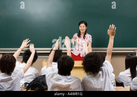 Students raising hands in class Stock Photo