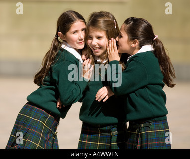 Young students whispering in courtyard Stock Photo