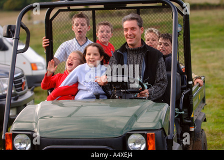 A FAMILY GROUP RIDE ON A FARMERS KAWASAKI MULE IN A FIELD IN GLOUCESTERSHIRE UK Stock Photo