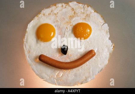 Fried breakfast of eggs and sausage made into a smiling face. Stock Photo