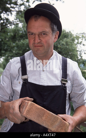 Colin Richards making bricks by hand with a finished one Stock Photo