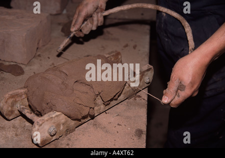 Colin Richards making bricks by hand using a wire bow to cut the clay to shape it in mould Stock Photo