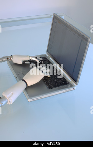 Humanoid robotic hands operating a laptop computer Stock Photo