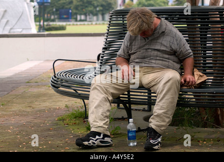 Homeless man sleeping on park bench New Orleans LA USA Stock Photo