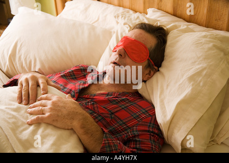 Man sleeping with eye mask Stock Photo
