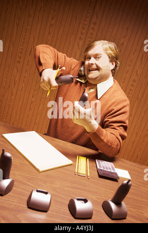 Businessman at desk using multiple telephones Stock Photo