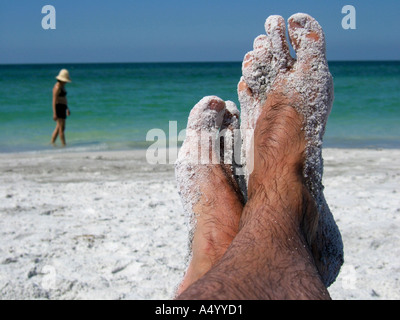 a pair of feet covered in sand Stock Photo