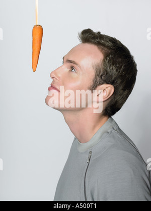 Man looking at dangling carrot Stock Photo