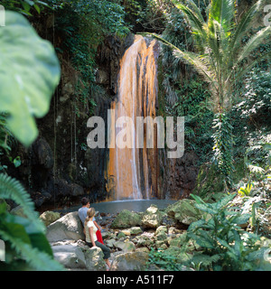 Couple in Soufriere Botanical Gardens look at waterfall surrounded by lush greenery on St Lucia Island The Caribbean Stock Photo