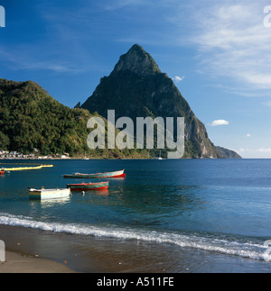 View across the bay with local boats moored Petit Piton mountain peak in background at Soufriere town St Lucia The Caribbean Stock Photo