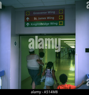 A family walking down a hospital corridor at St Georges Hospital, Tooting, London, UK. Stock Photo