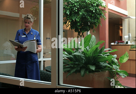 A registered nurse examines the records of a patient at a private hospital in St Johns Wood London UK Stock Photo