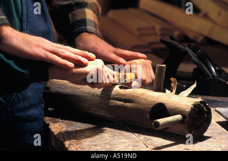 Caucasian father helping son use draw knife to make bird house Stock Photo