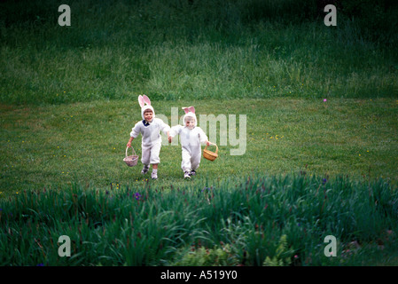 Two brothers in bunny costumes searching for Easter eggs Stock Photo