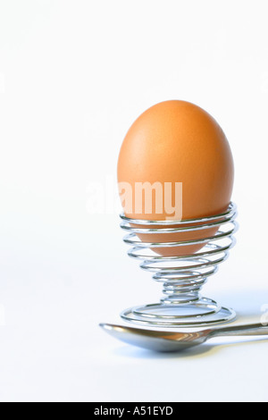 Egg in metal spiral egg cup with spoon Stock Photo