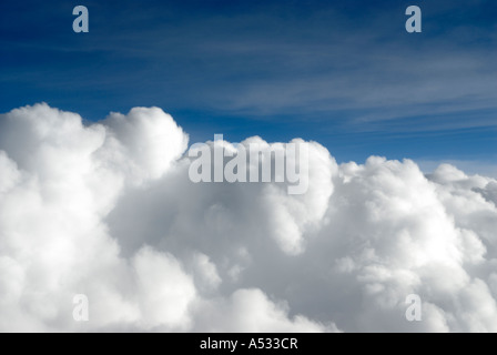 Puffy white cumulus clouds close up from airplane with blue sky