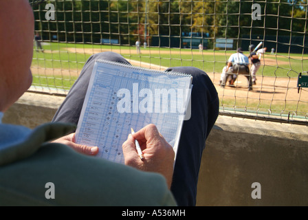 A man keeps score of the game from behind home plate Stock Photo