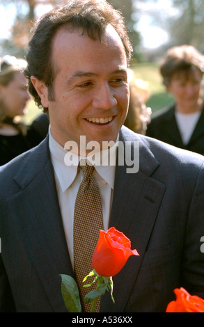 Happy man holding a rose at cemetery. Crystal Lake Cemetery Minneapolis Minnesota USA Stock Photo