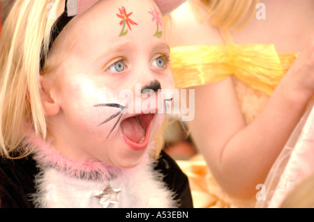 British girl at birthday party with face paint looking happy and having fun, London UK Stock Photo