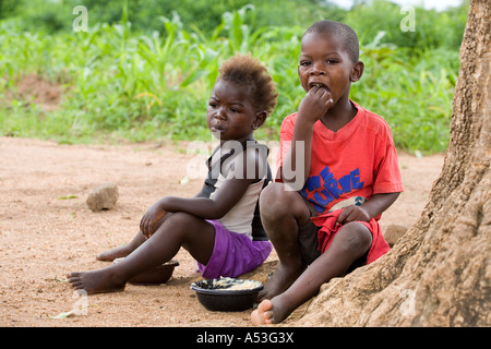 Hungry children eating phala as part of the Joseph Project feeding programme in the village of Buli, Malawi, Africa Stock Photo