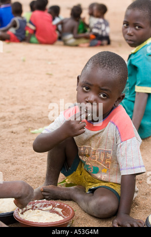 Hungry children eating phala as part of the Joseph Project feeding programme in the village of Buli, Malawi, Africa Stock Photo