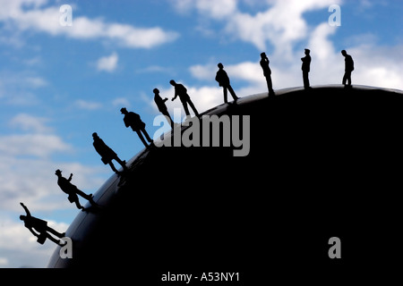 Silhouette of business figurines placed in a row on an earth globe Stock Photo